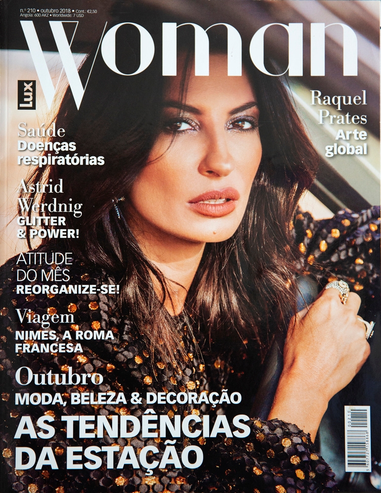 A young woman sits in a car, smiling for Woman magazine