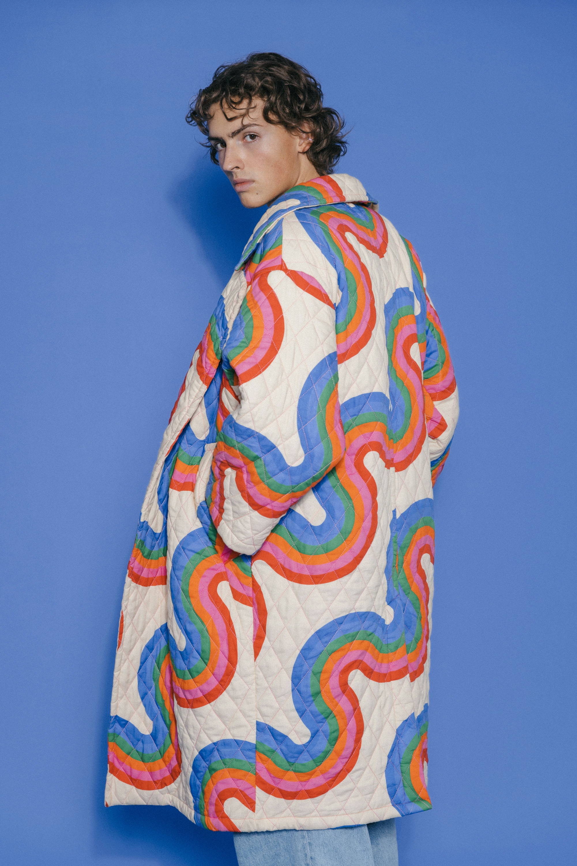 Man wearing a blue jacket with colorful swirls