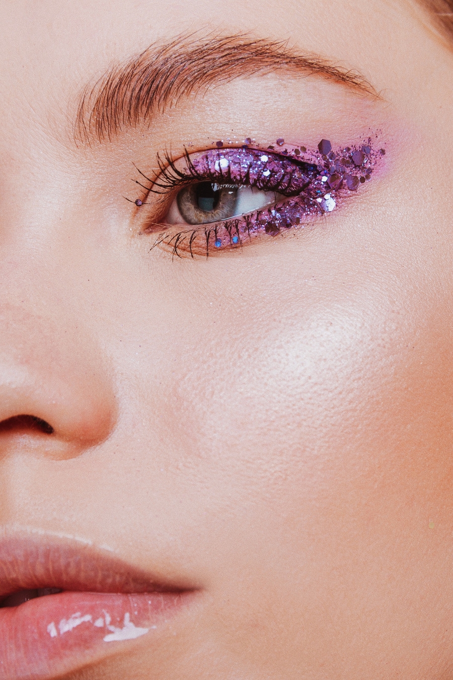 A woman with a purple shimmer eye shadow looking at the camera